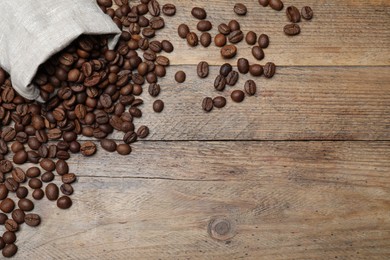 Bag with roasted coffee beans on wooden table, flat lay. Space for text