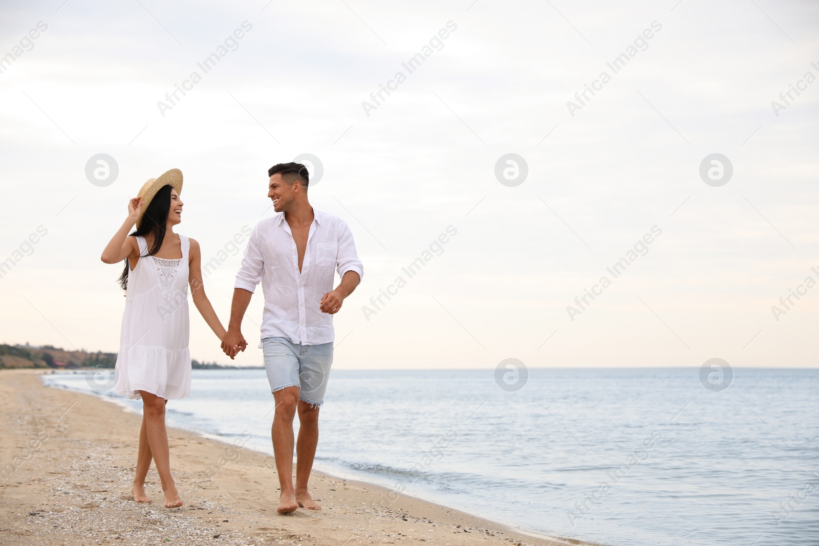 Photo of Lovely couple walking on beach. Space for text