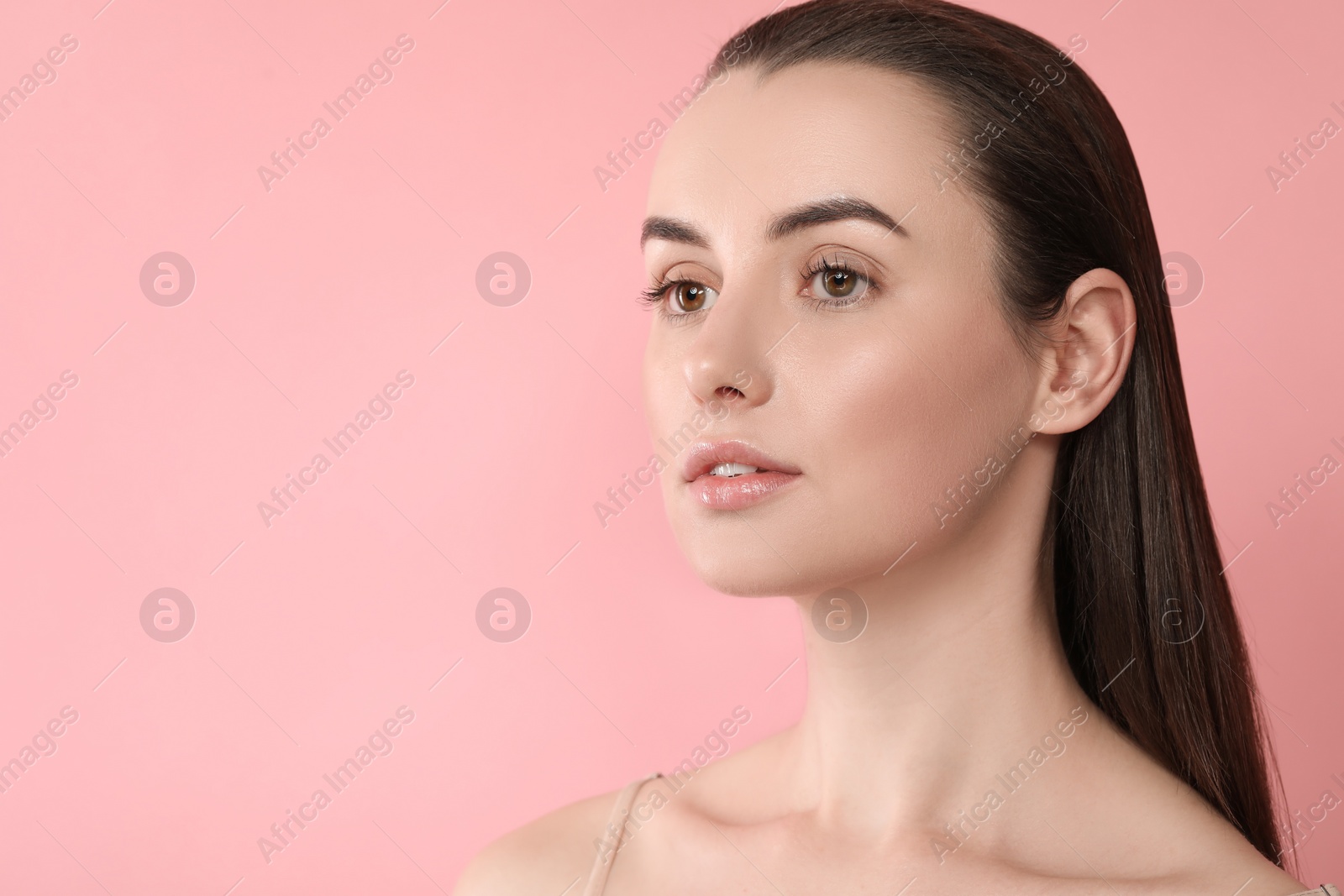 Photo of Portrait of beautiful young woman on pink background. Space for text