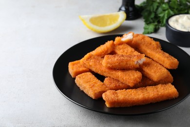 Photo of Fresh breaded fish fingers served on white table, space for text