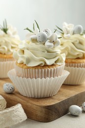 Tasty Easter cupcakes with vanilla cream on gray table, closeup