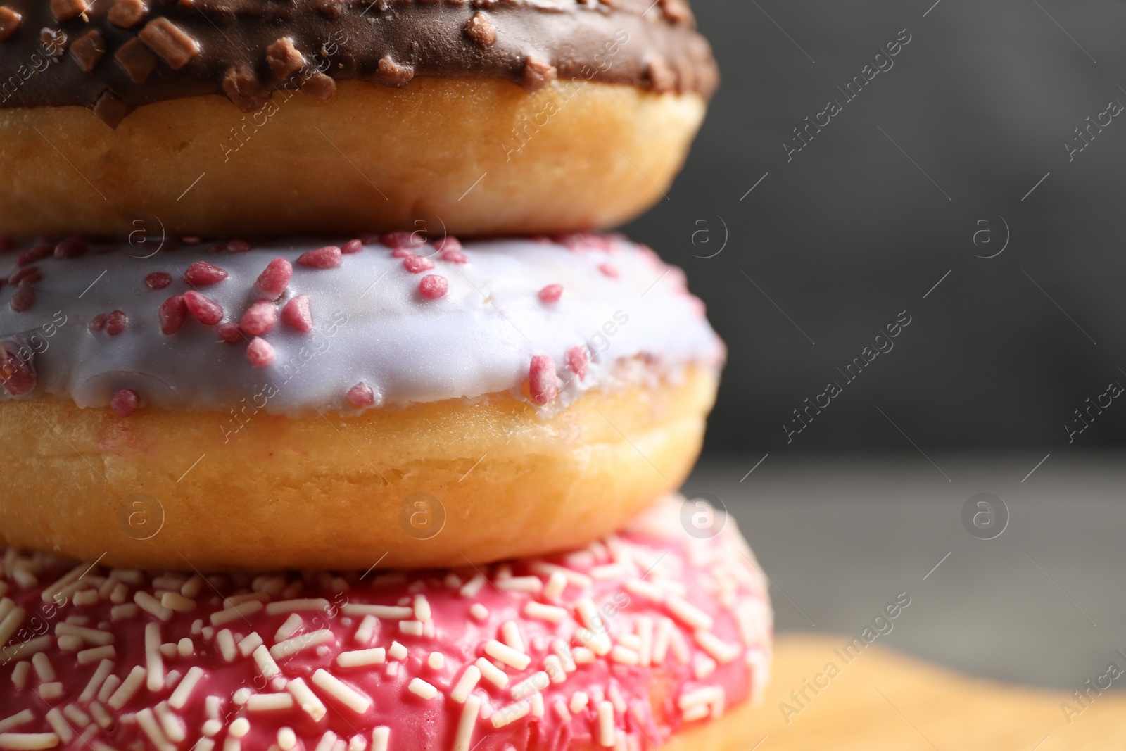 Photo of Delicious glazed donuts on grey background, closeup