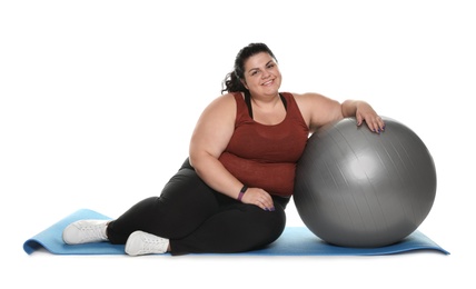 Photo of Overweight woman with mat and gym ball on white background