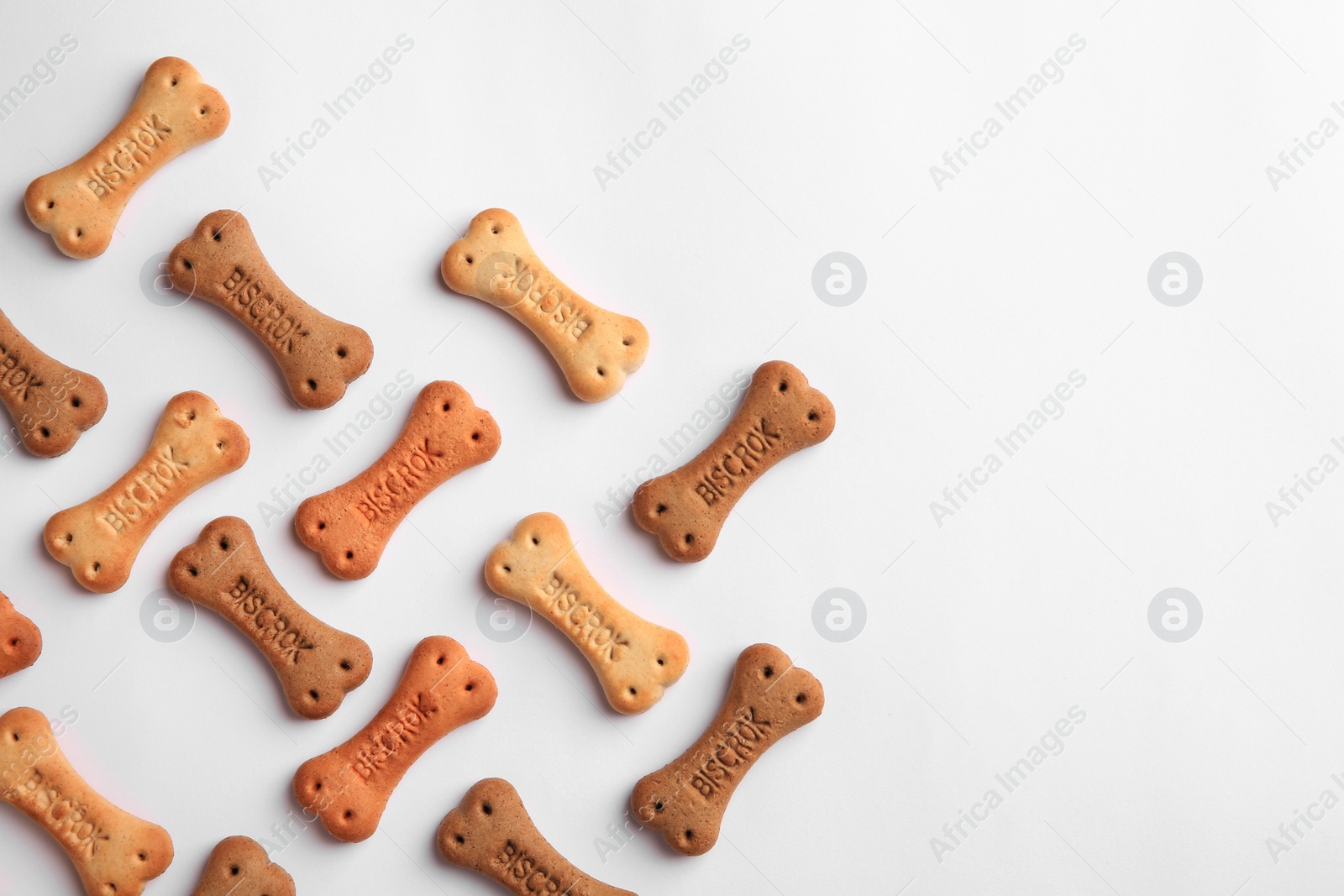 Photo of Bone shaped dog cookies on white background, top view. Space for text