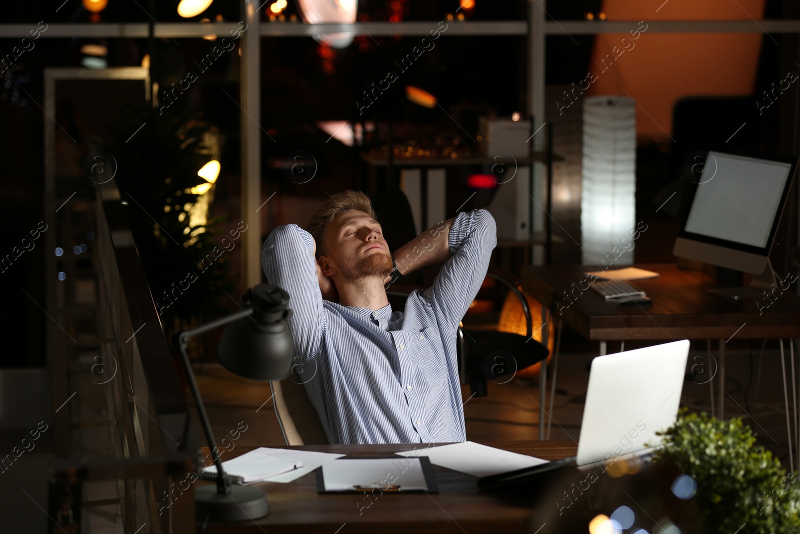 Photo of Young man working in office at night