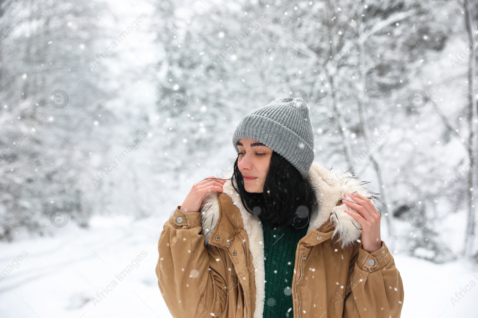 Photo of Young woman wearing warm clothes outdoors on snowy day. Winter vacation