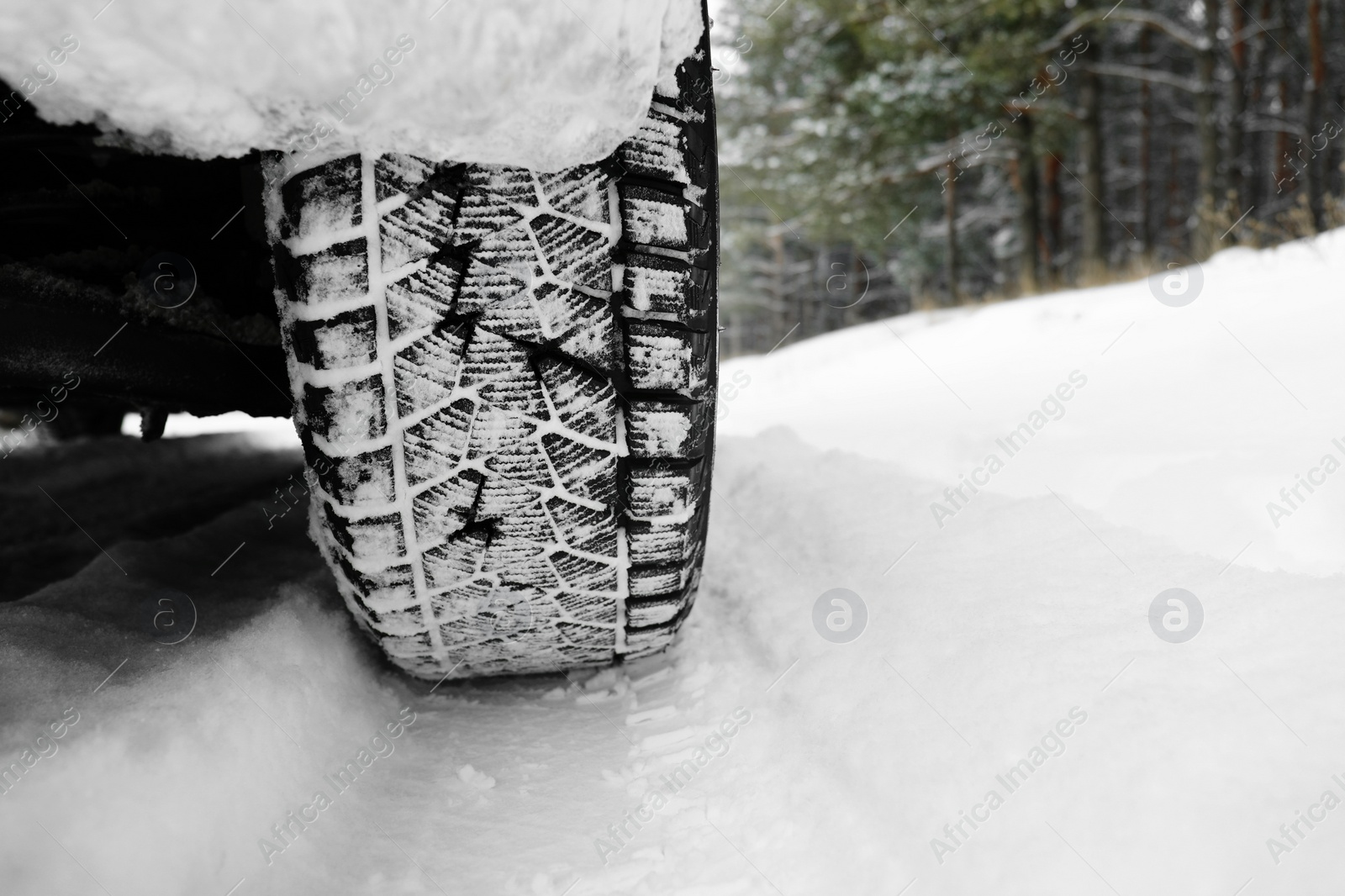 Photo of Snowy country road with car on winter day, closeup. Space for text