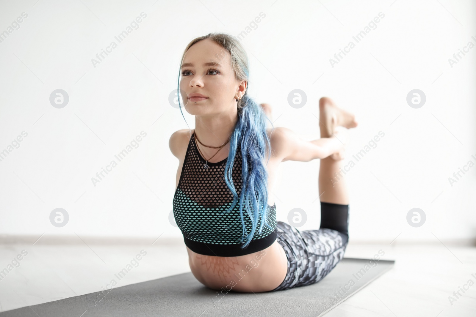 Photo of Young woman practicing yoga indoors