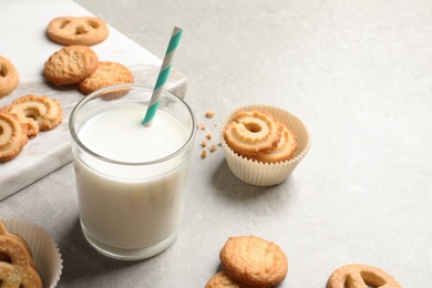 Photo of Danish butter cookies and glass of milk on grey table. Space for text