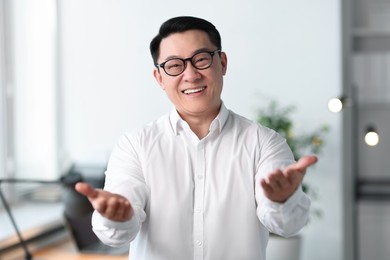 Photo of Portrait of smiling businessman in glasses indoors