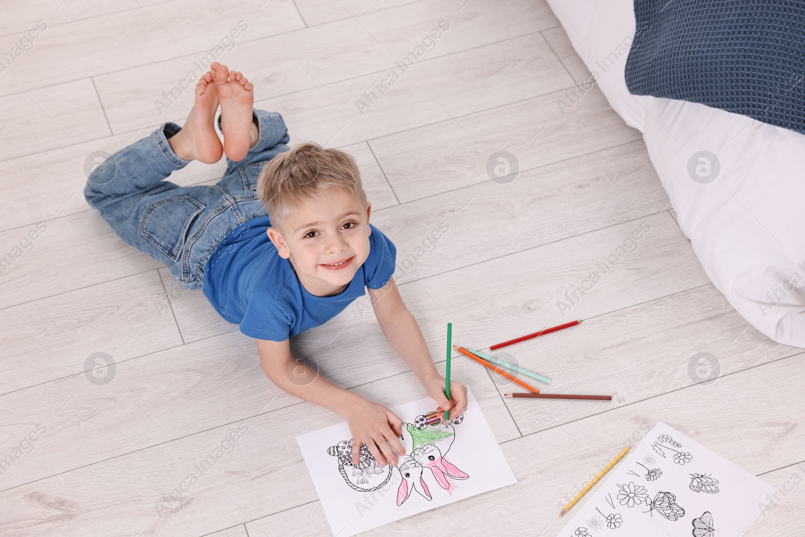 Photo of Cute little boy coloring on warm floor at home. Heating system