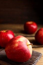 Photo of Fresh ripe red apples on wooden table. Space for text