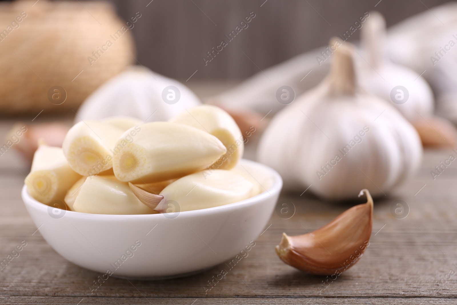 Photo of Aromatic garlic cloves and bulbs on wooden table, closeup. Space for text