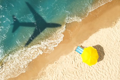 Image of Shadow of airplane above sandy coast, aerial view. Summer vacation