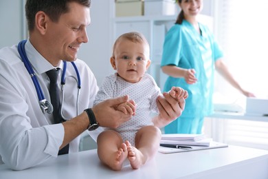 Photo of Pediatrician examining cute little baby in clinic