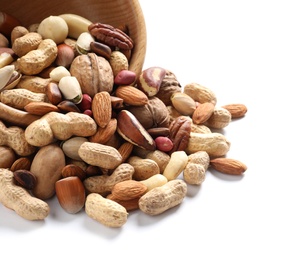 Photo of Overturned bowl with mixed organic nuts on white background, closeup