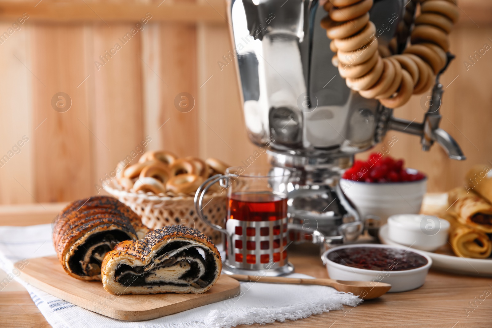 Photo of Traditional Russian samovar and treats on wooden table