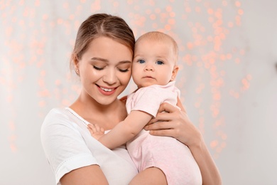 Portrait of happy mother with her baby against blurred lights