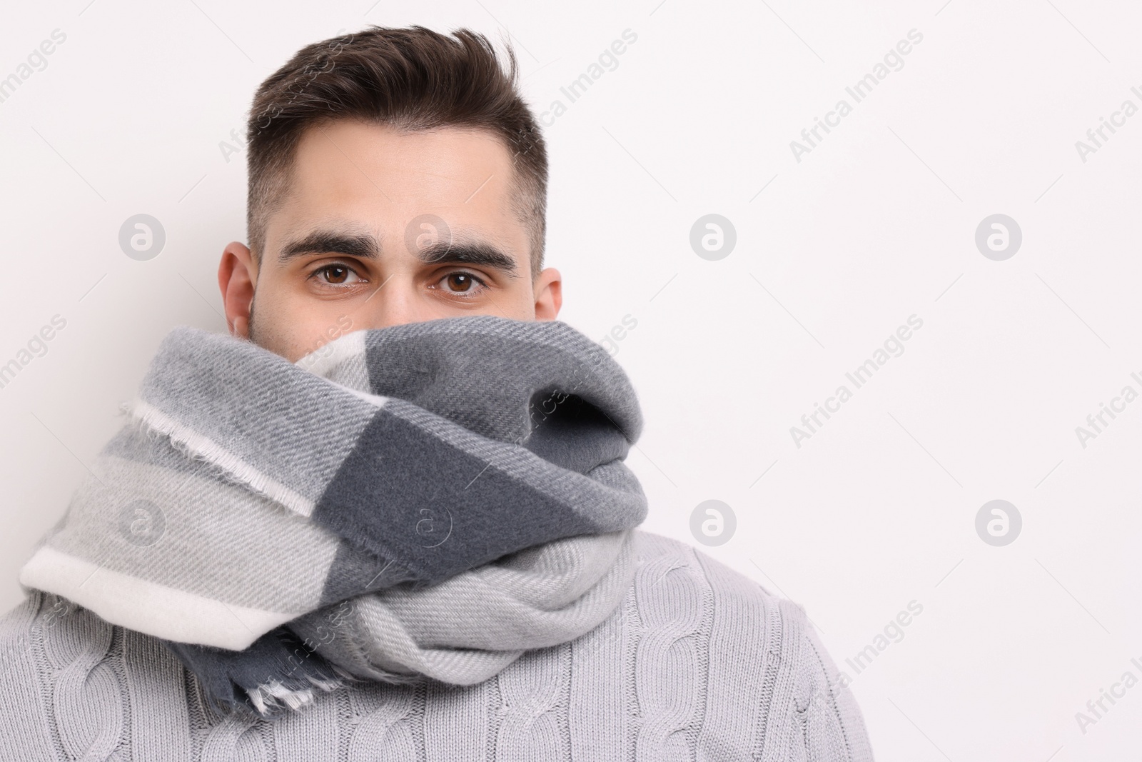 Photo of Man in warm scarf on light background. Space for text