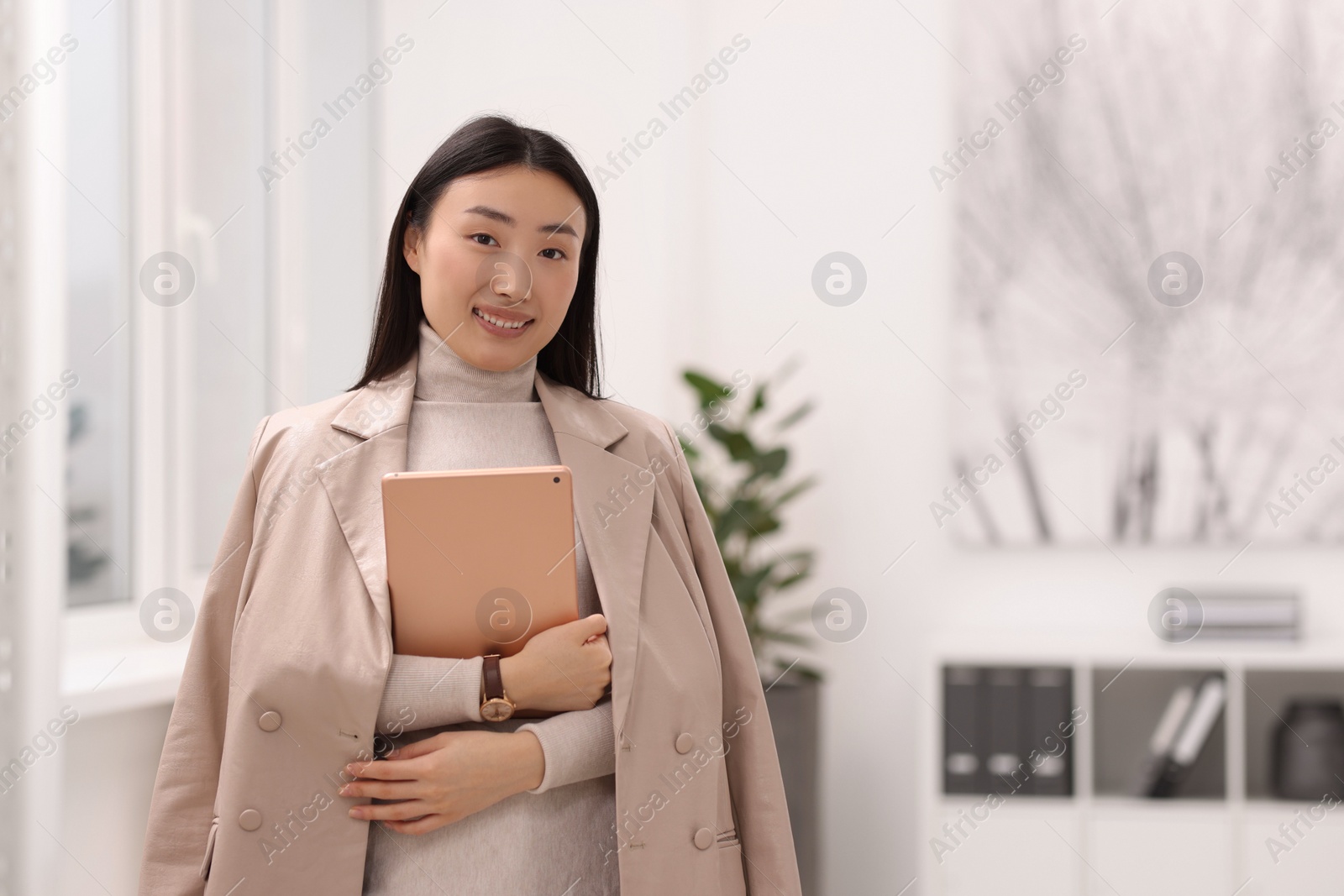 Photo of Portrait of smiling businesswoman with tablet in office. Space for text