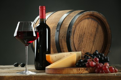 Photo of Winemaking. Composition with tasty wine and barrel on wooden table against gray background