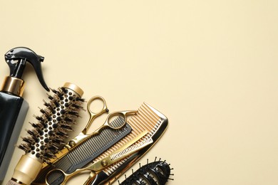 Different hairdresser tools on beige background, flat lay. Space for text