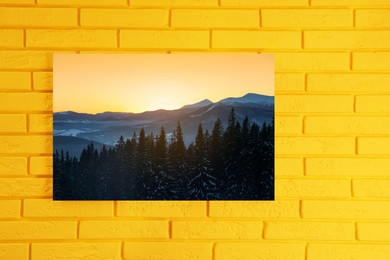 Image of Canvas with printed photo of forest and mountain landscape on yellow brick wall