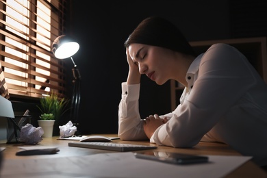 Businesswoman stressing out at workplace late in evening