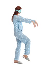 Photo of Young woman wearing pajamas, mask and slippers in sleepwalking state on white background