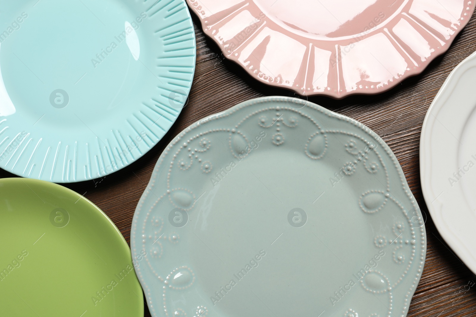 Photo of Beautiful ceramic plates on wooden table, flat lay