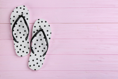 Photo of Stylish flip flops on pink wooden background, flat lay. Space for text