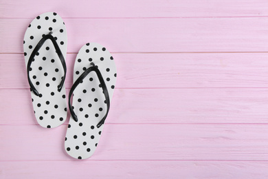 Stylish flip flops on pink wooden background, flat lay. Space for text