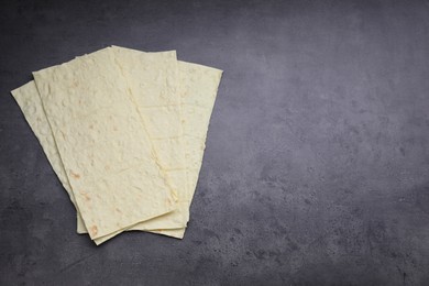 Delicious Armenian lavash on dark table, top view. Space for text