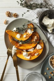 Photo of Delicious pumpkin slices served with thyme and cheese on white wooden table, flat lay