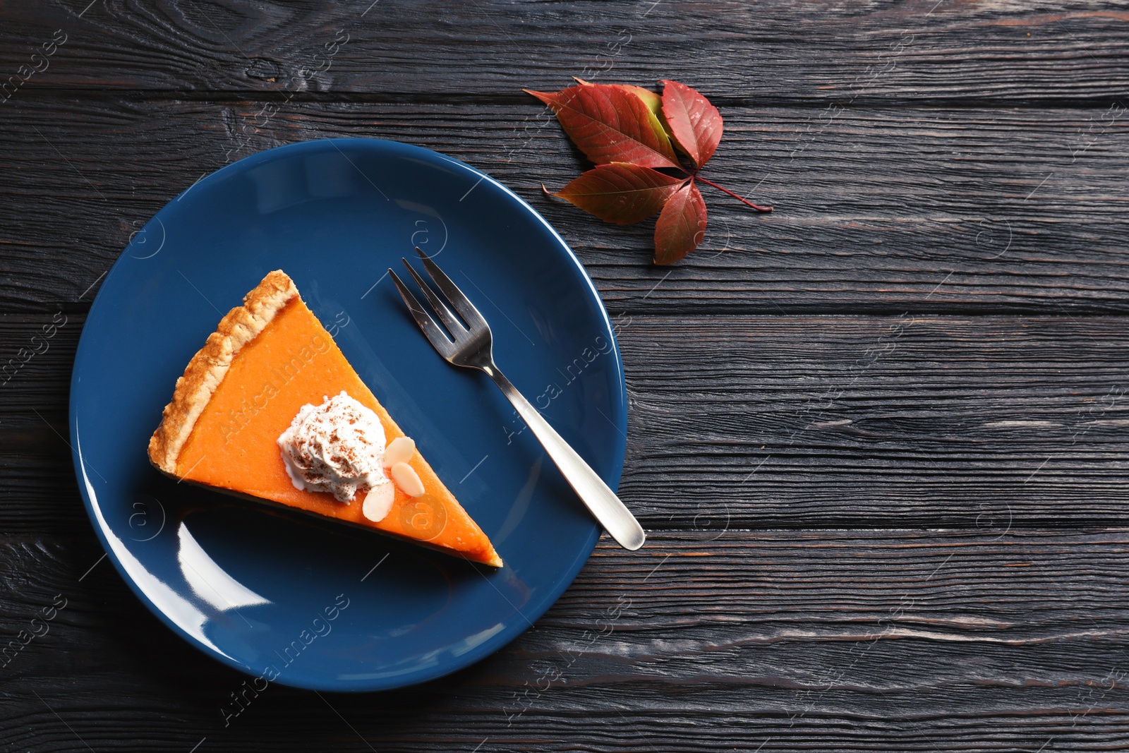 Photo of Flat lay composition with piece of fresh delicious homemade pumpkin pie and space for text on wooden background