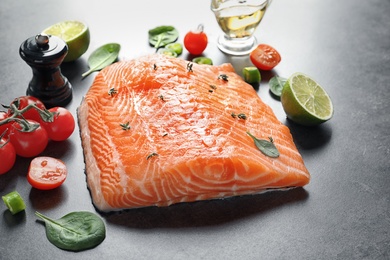 Photo of Raw salmon fillet and ingredients for marinade on table