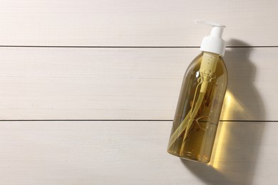 Photo of Dispenser of liquid soap on white wooden table top view. Space for text