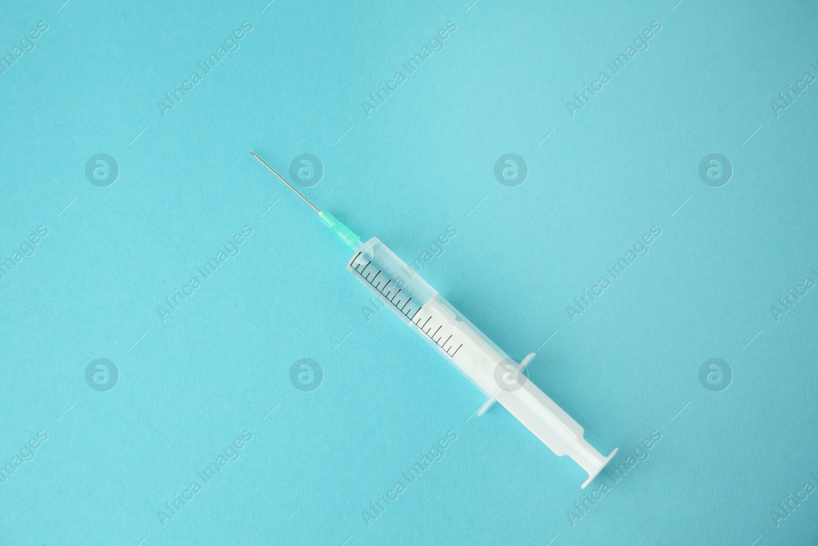 Medical syringe on light blue background, top view Photo of Medical syringe on light blue background, top view