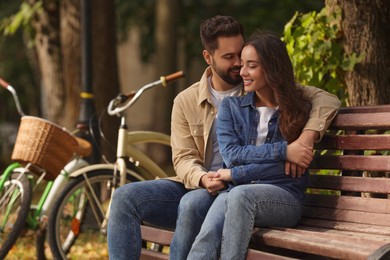 Beautiful couple spending time together in park, space for text