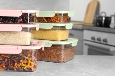 Photo of Many boxes with different food on table in kitchen, space for text