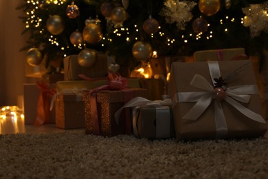 Many gift boxes under decorated Christmas tree at home