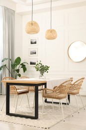 Photo of Stylish dining room with cozy furniture, mirror and plants