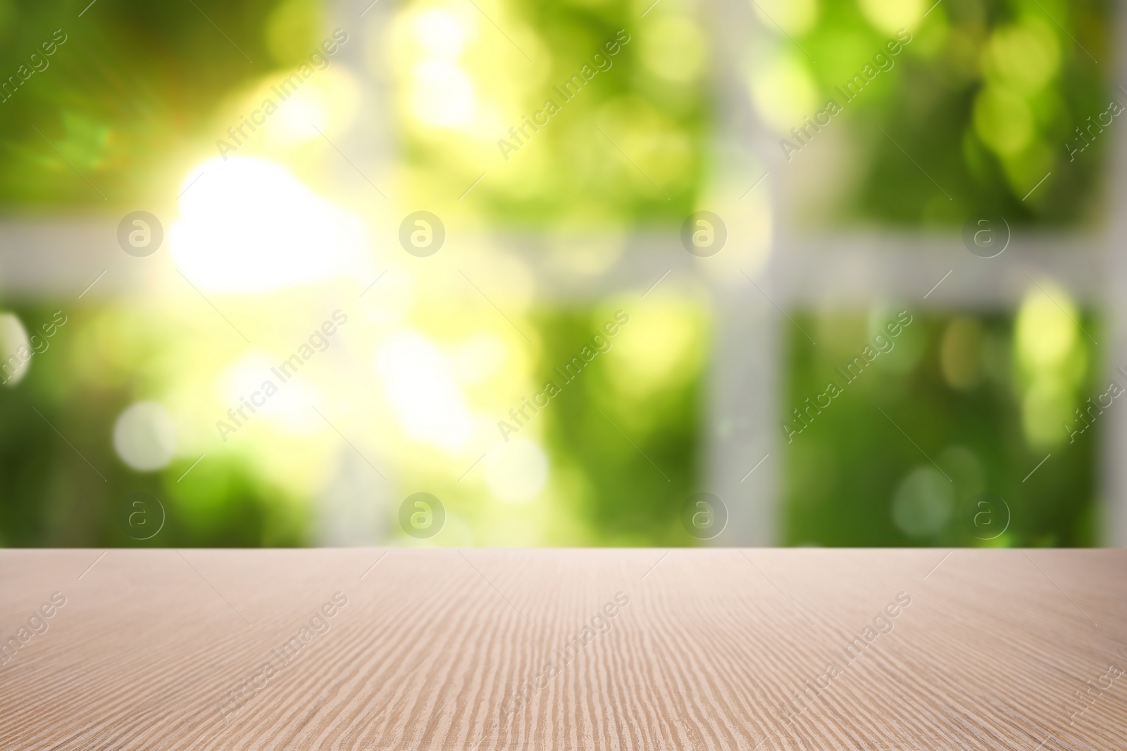 Image of Empty wooden table in front of window. Sunny morning 