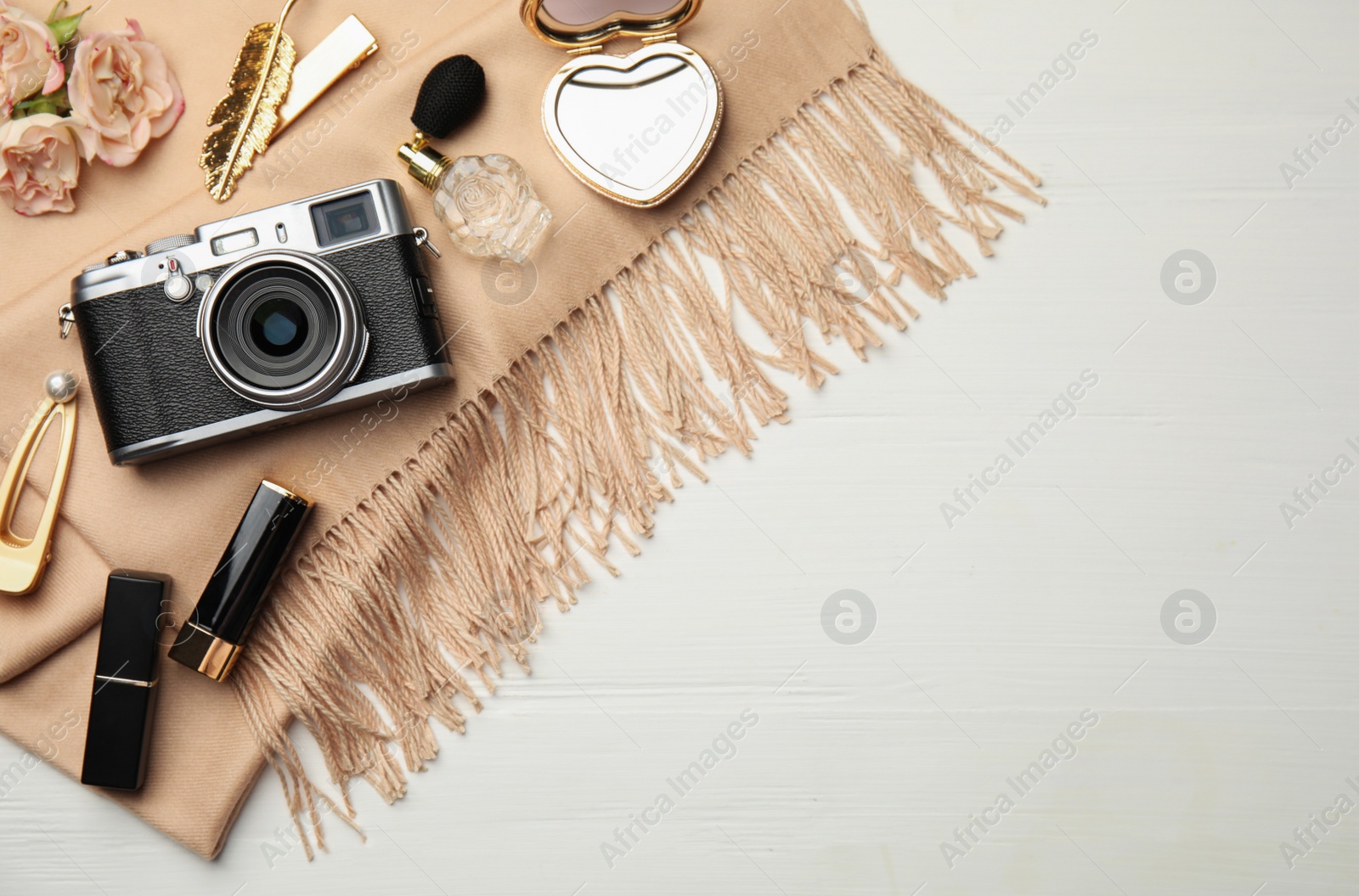 Photo of Flat lay composition with makeup products and camera on white wooden background. Space for text