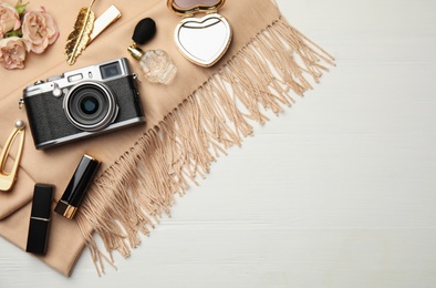 Photo of Flat lay composition with makeup products and camera on white wooden background. Space for text