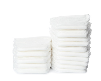 Photo of Stacks of baby diapers isolated on white