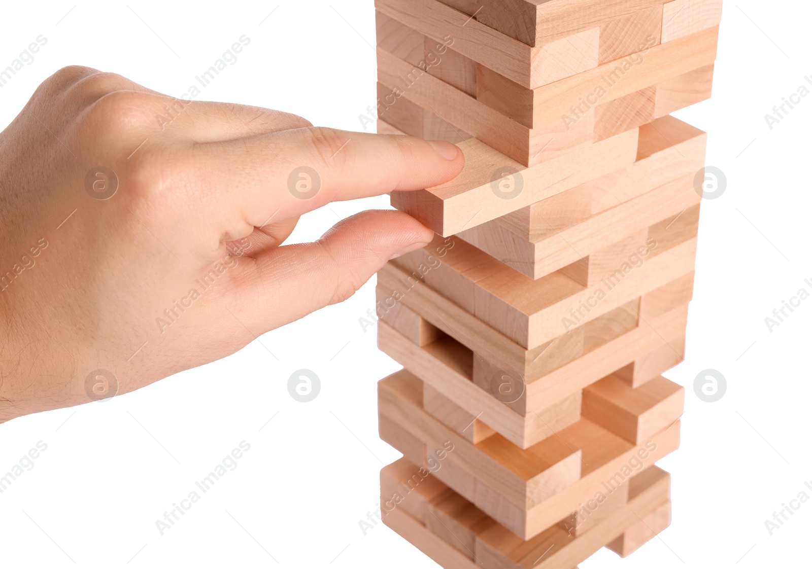 Photo of Playing Jenga. Man removing wooden block from tower on white background, closeup