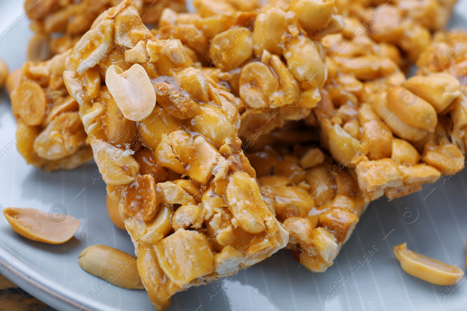 Photo of Delicious peanut kozinaki bars on plate, closeup