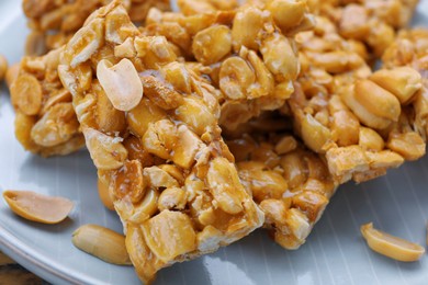 Photo of Delicious peanut kozinaki bars on plate, closeup