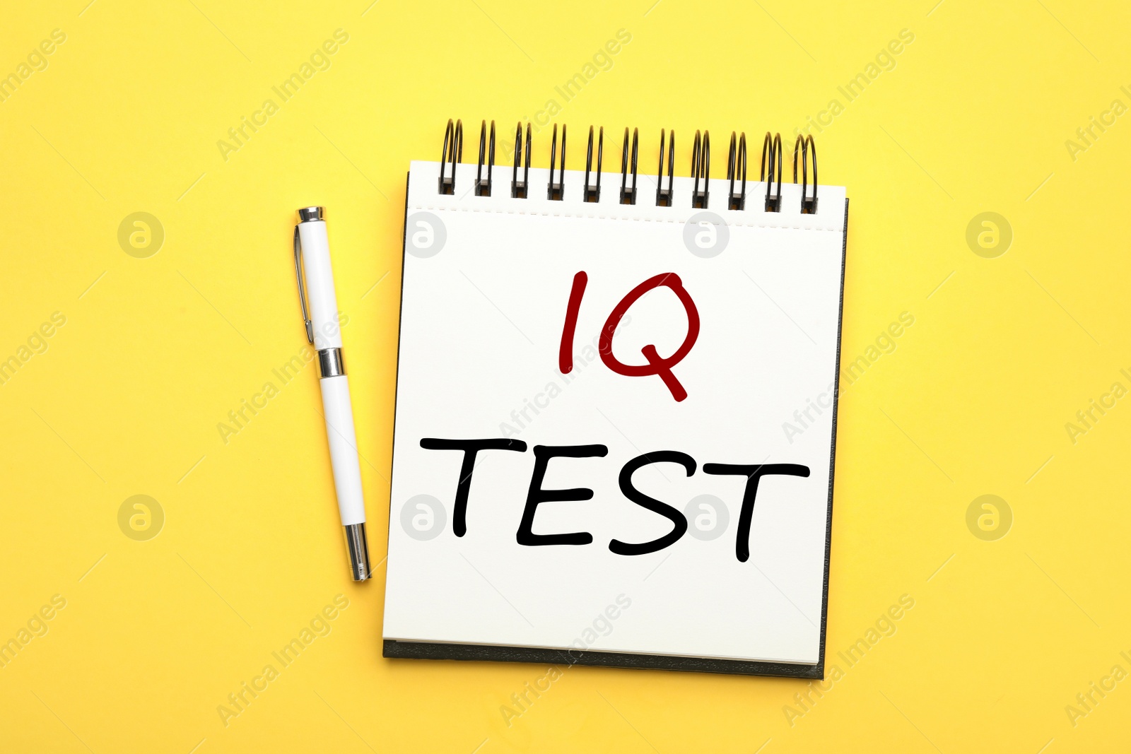 Image of Notebook with text IQ Test and pen on yellow background, flat lay
